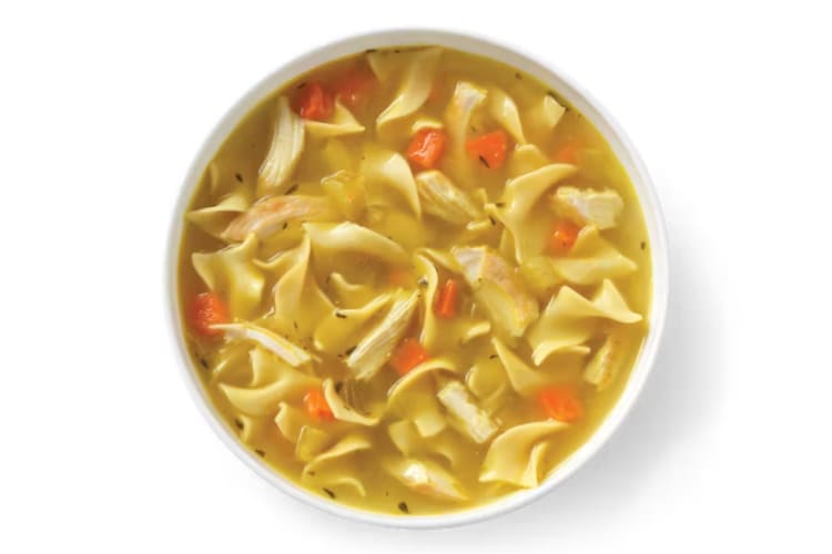 A bowl of chicken noodle soup with carrots