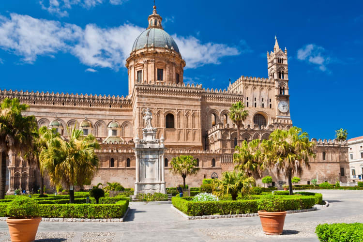 Palermo Cathedral with palm trees in front on a clear day