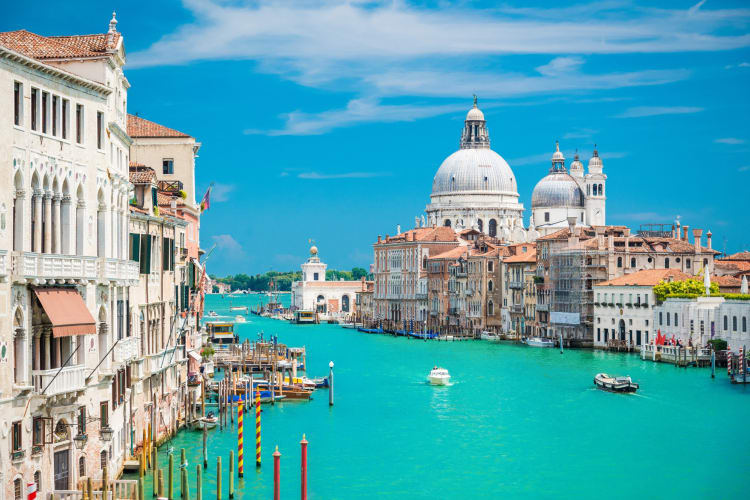 A view of bright blue water with buildings on either side in Venice, Italy