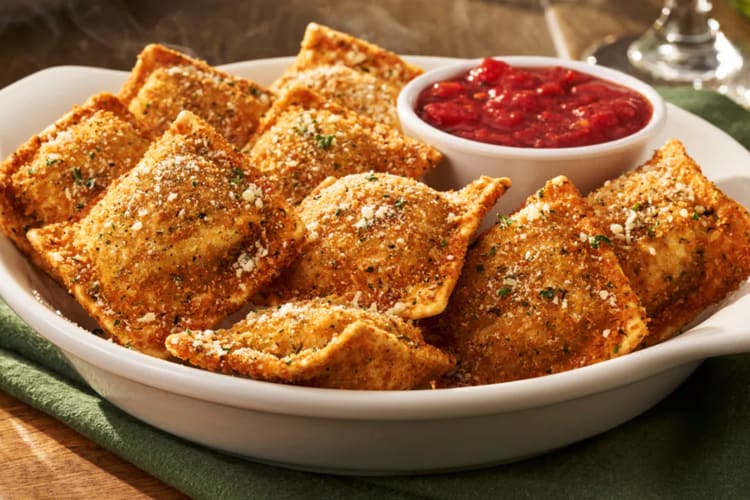A bowl of toasted ravioli with marinara dipping sauce