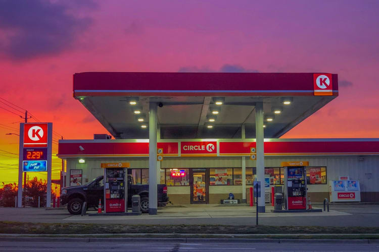 A gas station with a Circle K store under a purple sky at sunset
