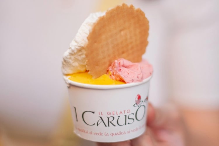 A tub of gelato with a round wafer