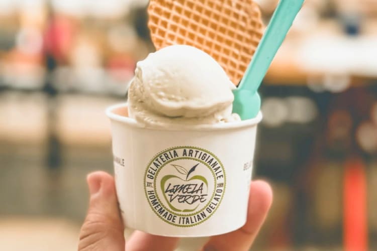 A cup with gelato, a wafer and a plastic spoon