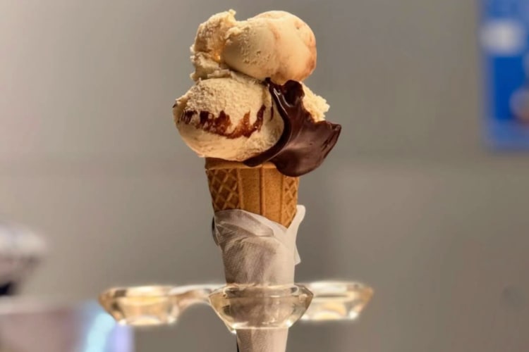 An ice cream cone filled with gelato and a chocolate decoration
