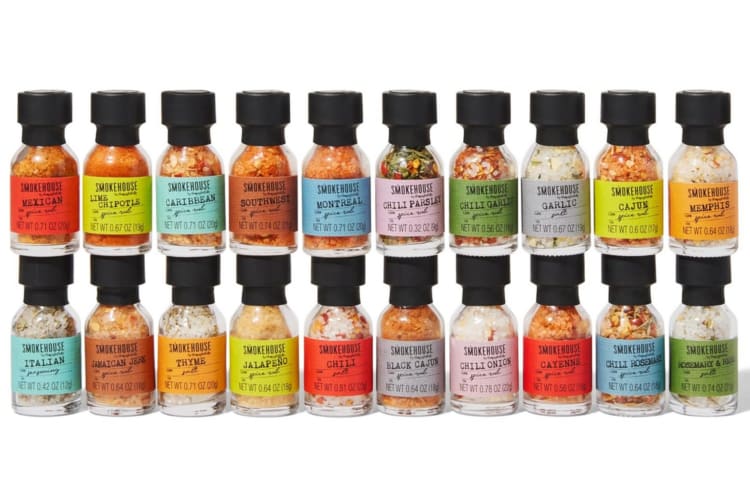 Two rows of glass bottles with spices in them