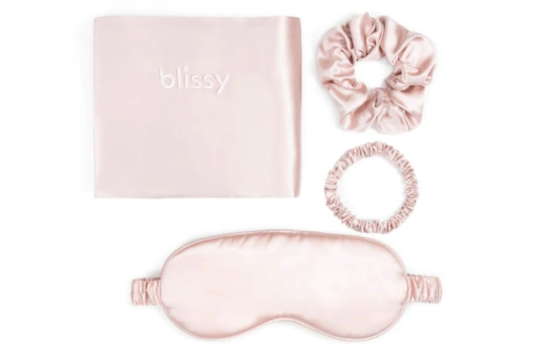 A pink sleep pillow case, sleep mask and two scrunchies