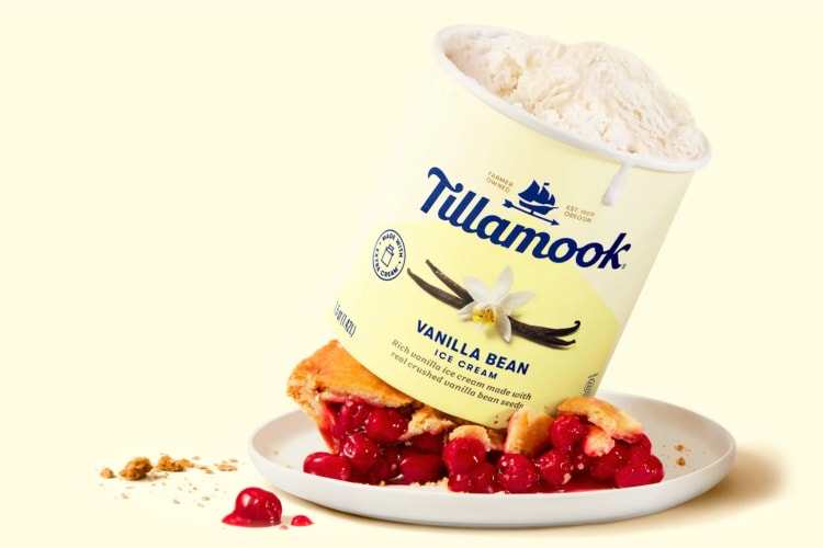 A tub of Tillamook vanilla ice cream on top of a slice of cherry pie