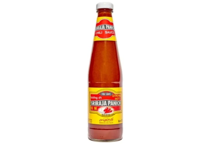 A bottle of Sriraja Panich Sriracha Chili Sauce with red and yellow labels