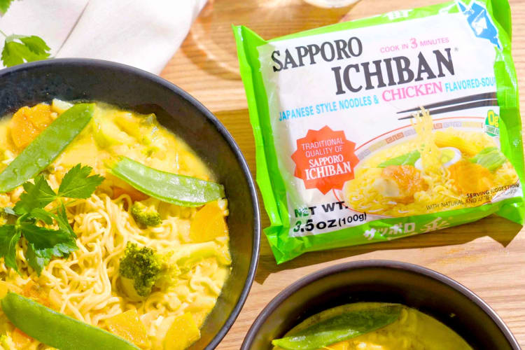 A packet of instant ramen next to a bowl of noodle soup