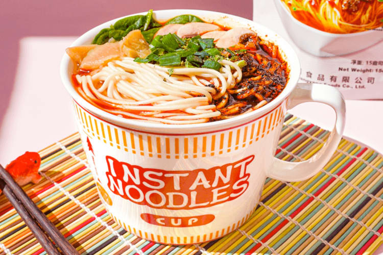 A cup of instant noodles with various toppings