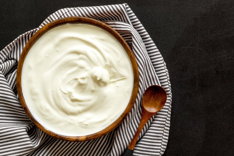 A wooden bowl of Greek yogurt