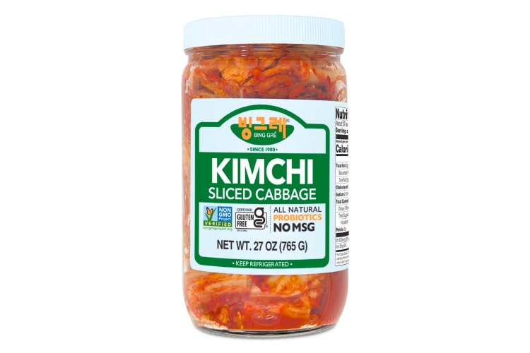 A glass jar of kimchi with a green label