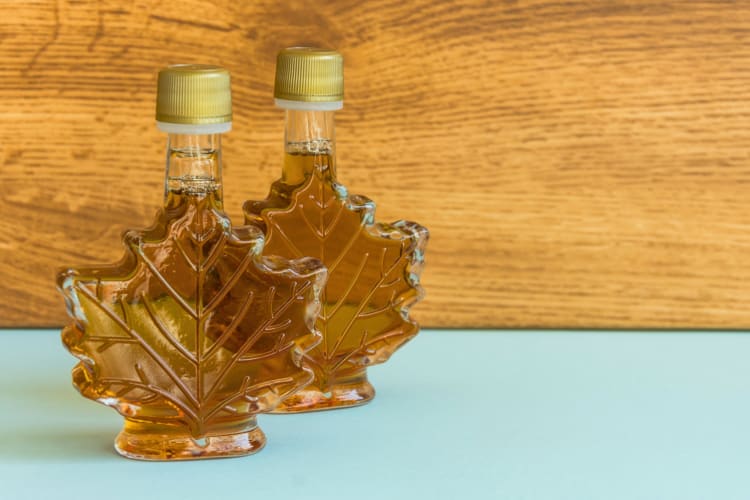 Two glass bottles of maple syrup
