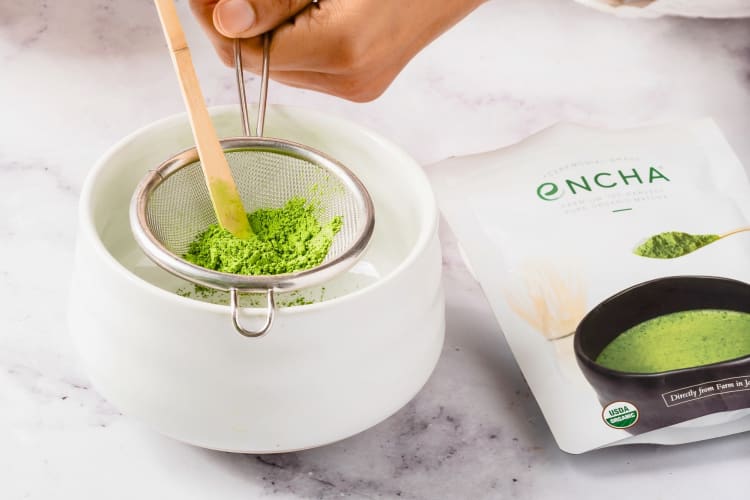 A bag of matcha next to matcha powder being strained