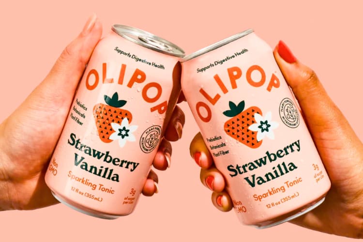 People cheersing two cans of strawberry vanilla soda