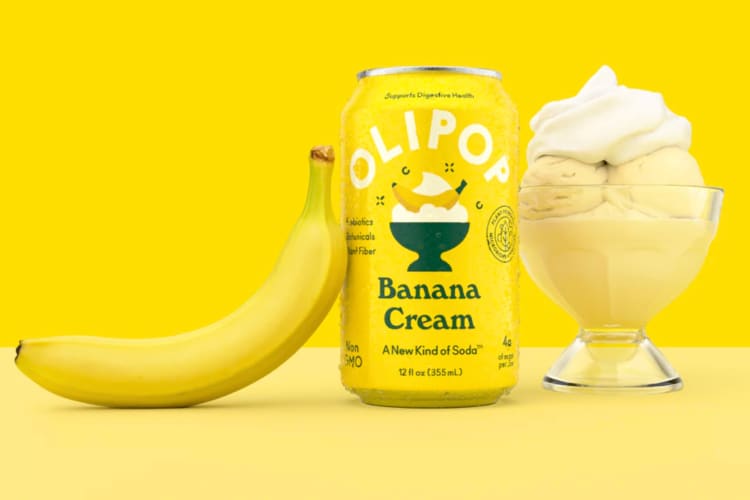 A can of banana cream soda next to a fresh banana and banana dessert