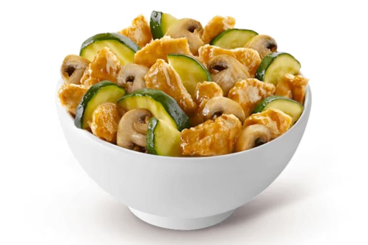 A bowl of stir-fried chicken with mushrooms and zucchini