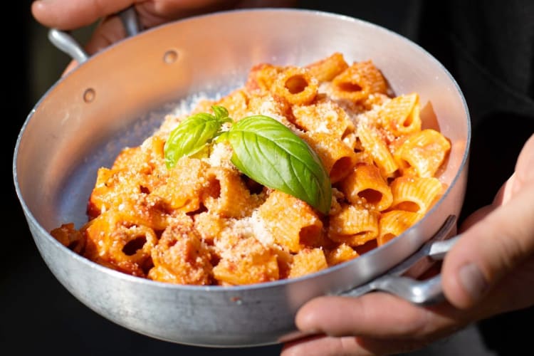 A pan with tomato rigatoni with basil