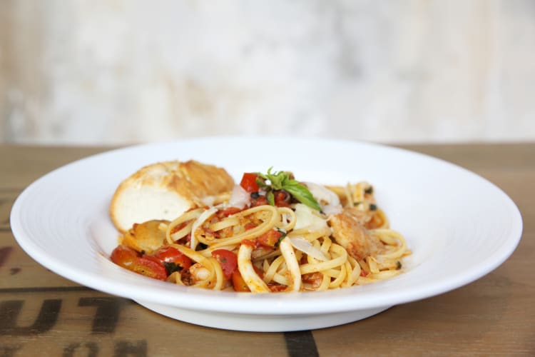 A bowl of seafood and tomato pasta