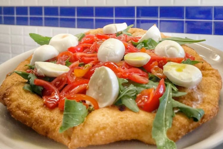 Fried pizza with mozzarella, tomato and arugula
