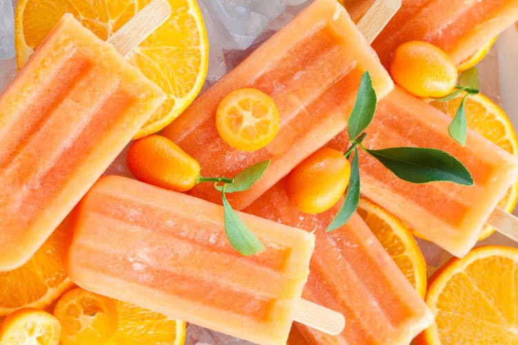 Orange, citrus flavored popsicles with fresh oranges and kumquats