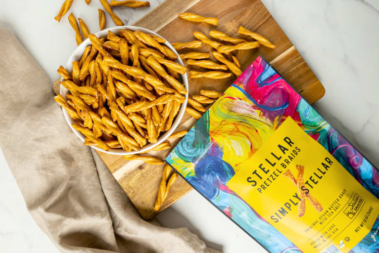 A bowl of pretzel twists next to their colorful packaging
