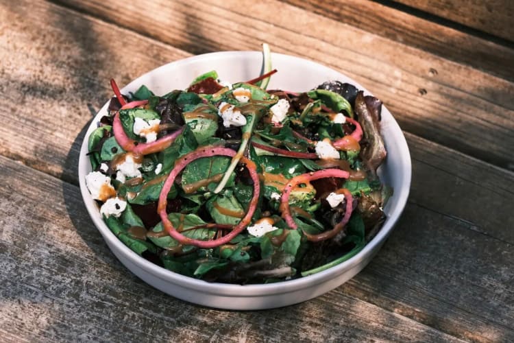 A bowl of salad on a wooden table