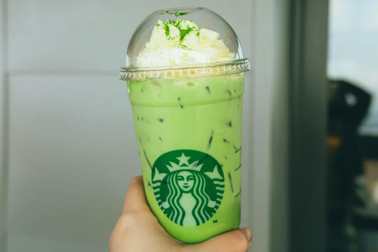 A personholding a Starbucks matcha Frappuccino 