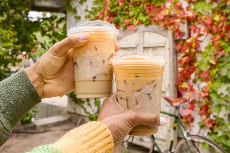 Two people holding iced Starbucks drinks