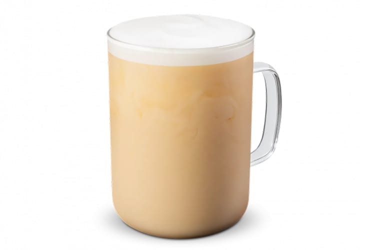 A hot tea latte in a glass mug