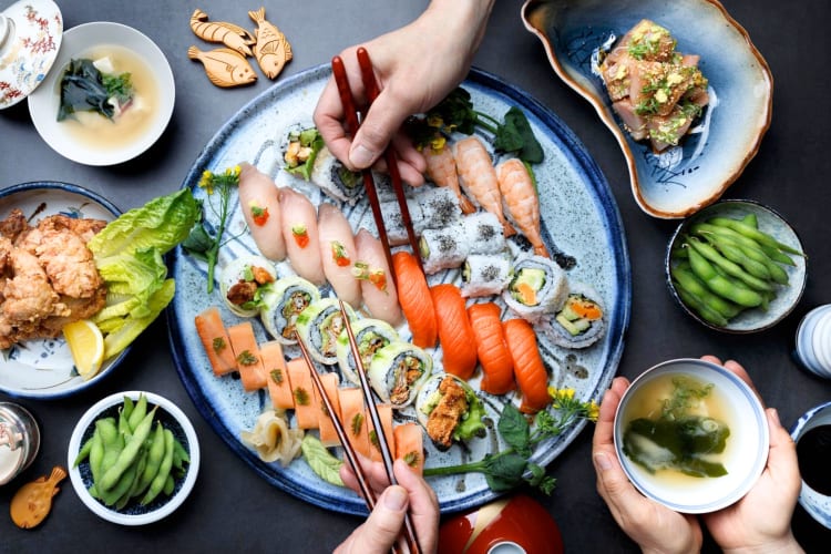 An array of different types of sushi and Japanese dishes on a table