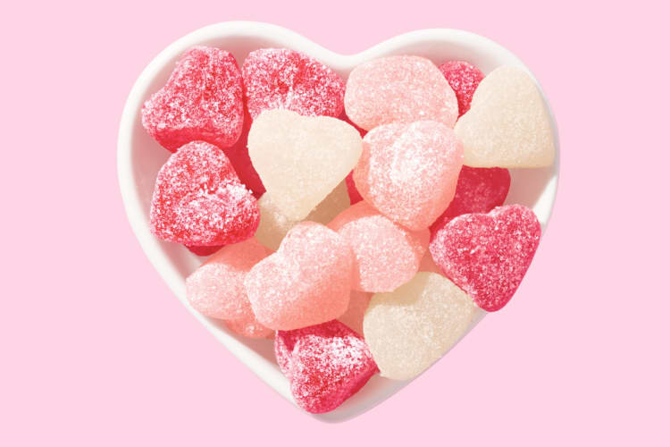 A white heart-shaped bowl with heart gummy candy