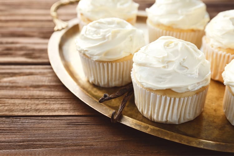 Vanilla cupcakes on a tray with vanilla pods