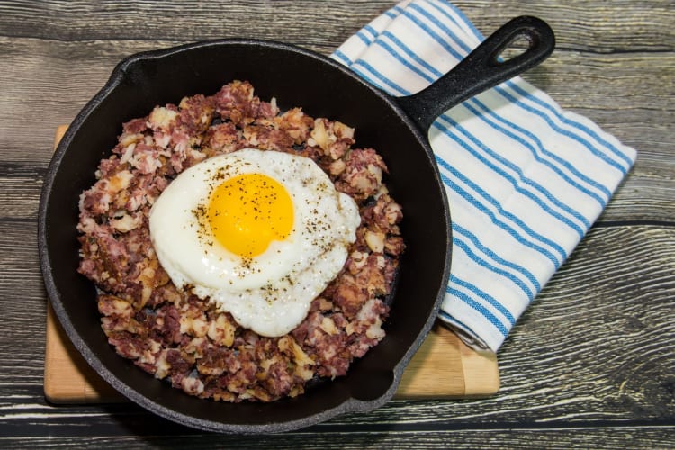A skillet with corned beef hash and a fried egg.