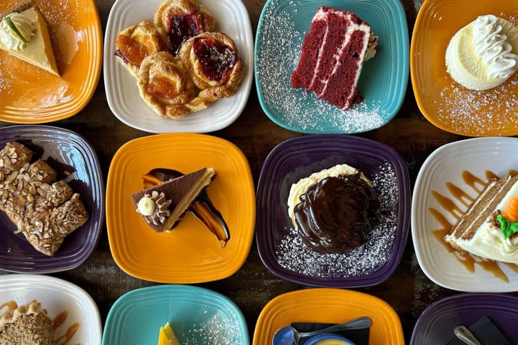 A wide selection of desserts on white plates at Range Café.