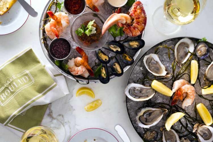 Oysters and shrimp on ice on a table with wine glasses