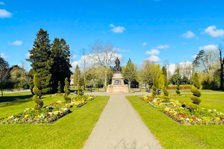 A park with a path, a statue and greenery