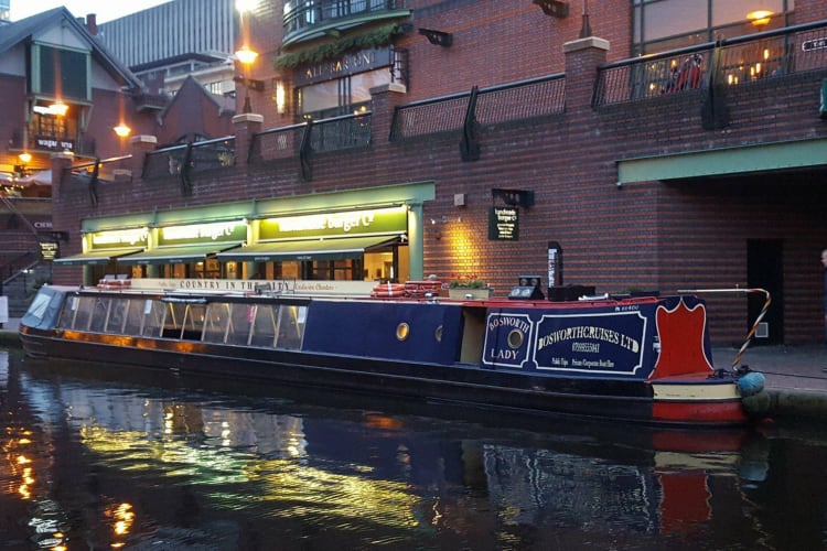 a canal boat ready to take tourists through the waterways of birmingham uk