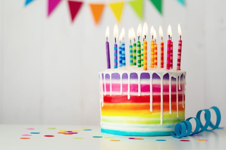 A rainbow birthday cake with colorful candles