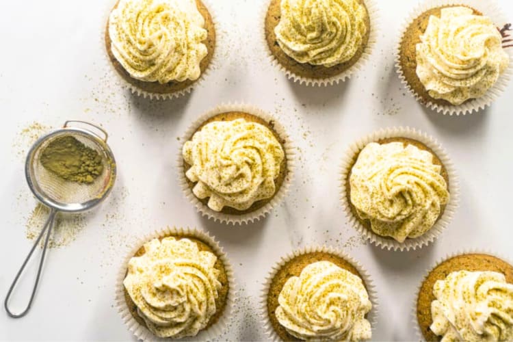 Aerial view of matcha cupcakes next to a sieve with matcha