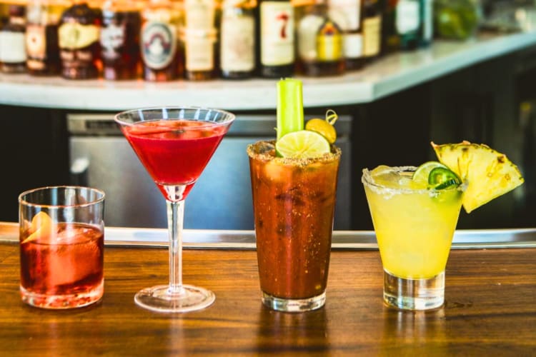 Four cocktails on a bar