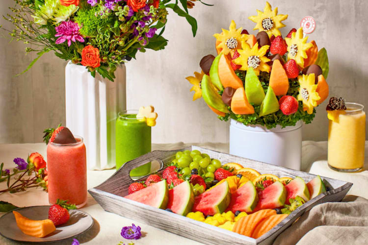A fruit edible arrangement, smoothies and a fruit platter