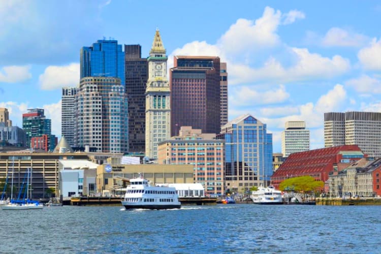 A city skyline next to the water with a boat on it