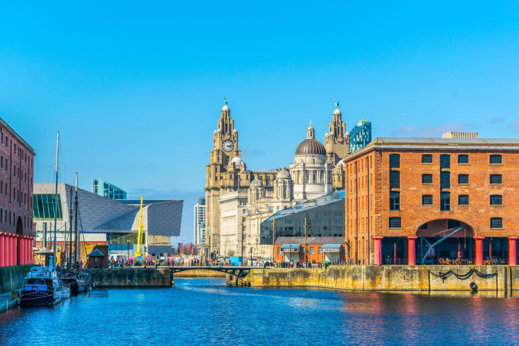 A waterway next to brick buildings under a clear blue sky