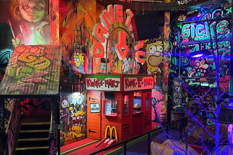 An indoor mini-golf course with grafitti