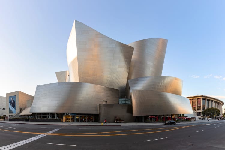 A modern silver building on the street under a blue sky