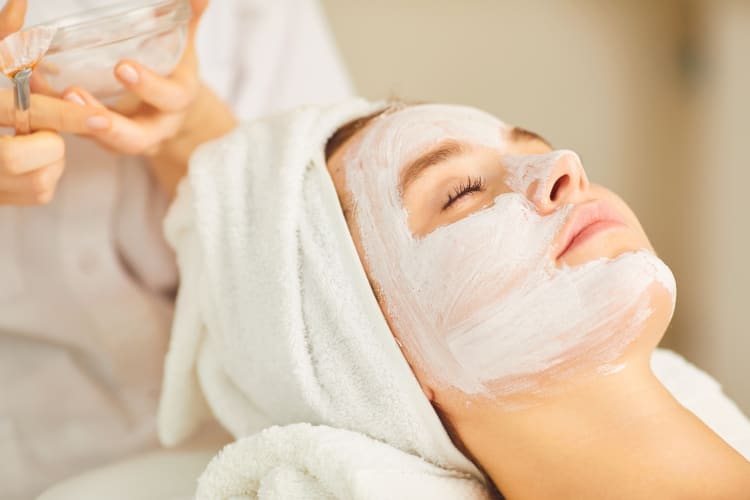 A woman at the spa with a white face mask on