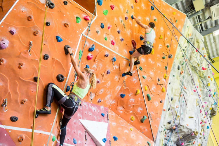 Two people climbing on an indoor rock climbing wall