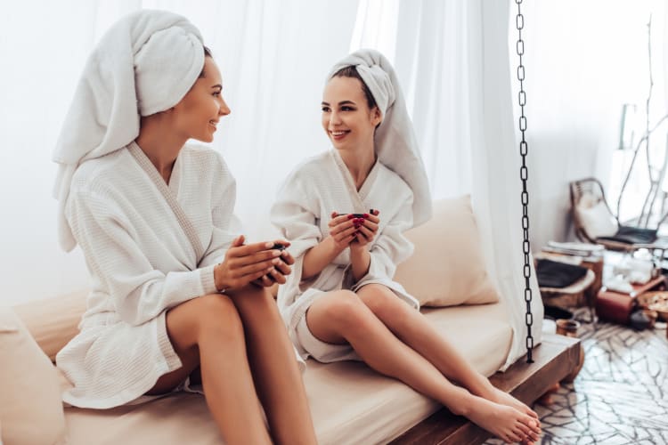 Two women in white bathrobes at the spa