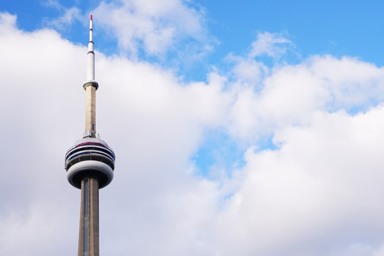 An observation tower next to blue sky with white clouds